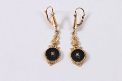 a pair of gold earrings with black stones on them