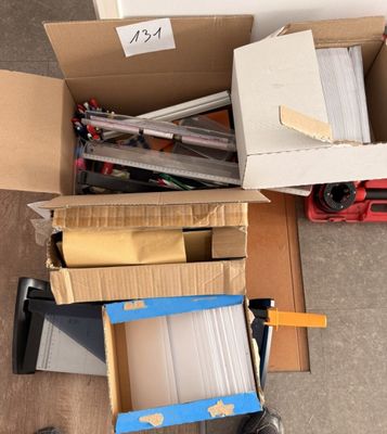 un carton rempli de boîtes et d'outils posé par terre
