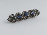 un gros plan sur une paire de boucles d'oreilles en saphir bleu et diamants