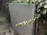 a silver refrigerator sitting in the middle of a garden
