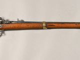 un vieux fusil en bois accroché au mur, orné d'une étoile