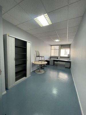 une pièce contenant un bureau, des étagères et une chaise