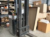 a fork lift truck parked in a warehouse with boxes