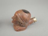 a small pipe with a man ' s face on it