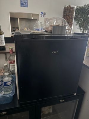 un petit réfrigérateur noir dans un coin de la cuisine