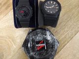 deux montres et un étui à montres posés sur une surface en bois