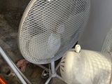 a fan sitting on the floor next to a chair