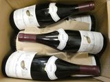 four bottles of wine in a cardboard box on the table