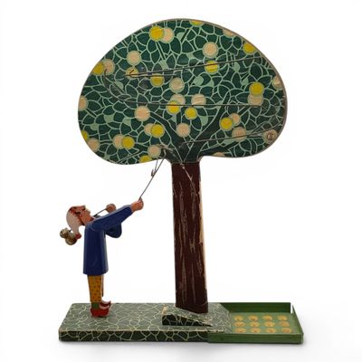 figurine représentant un homme tenant un cerf-volant devant un arbre