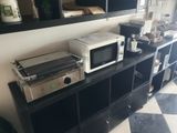 a microwave and a toaster sitting on a shelf in a kitchen