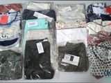 many different types of clothing in bags on a table