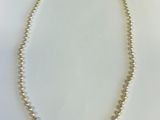 gros plan d'un collier de perles sur une surface blanche