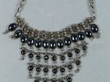 a close up of a necklace on a white surface