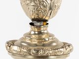 a silver vase with a bird on top of it