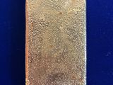 a close up of a gold bar on a blue surface