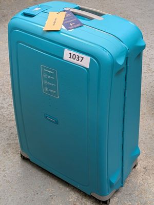 a blue suitcase with a tag on it sitting on the ground