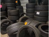 plusieurs pneus empilés les uns sur les autres devant la porte d'un garage