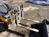 a small yellow ski - loader parked in the dirt