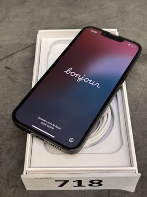 Un iPhone est posé sur une boîte, avec un chargeur dessus.