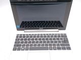 a white laptop with a black keyboard on a white table