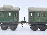 deux wagons verts placés côte à côte sur une surface blanche