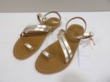 a pair of gold sandals on a white surface