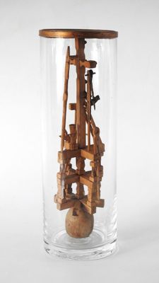 un bocal en verre contenant une structure en bois à l'intérieur
