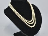 a close up of a necklace on a mannequin stand