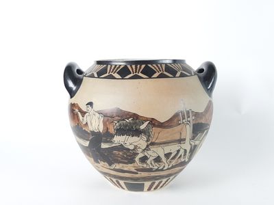 a vase with a painting on it on a white surface