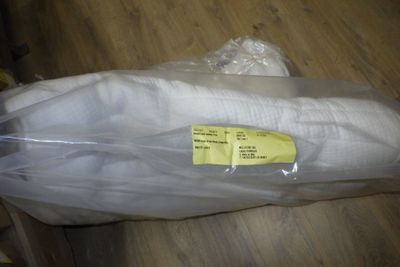 une banane emballée dans du plastique, posée par terre