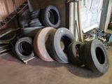 a lot of tires stacked on top of each other in a garage