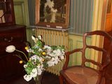 a vase of flowers sitting on a table next to a chair