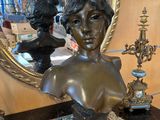 le buste d'une femme posée sur une table, avec un miroir
