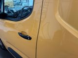 a yellow van parked in a parking lot next to a building