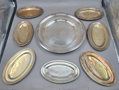 many silver plates in a box on a table