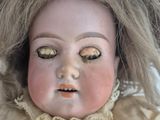 a close up of a doll wearing a straw hat