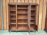 a large wooden bookcase with two doors open