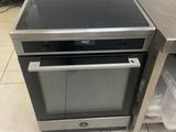four en acier inoxydable avec dessus en verre et porte s'ouvrant sur un sol carrelé