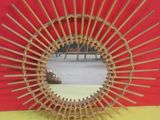 une photo d'un miroir fabriqué à partir de tiges de bambou