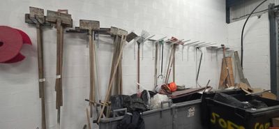 a lot of tools hanging on the wall in the garage