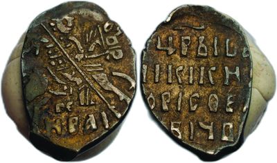 a close up of two old coins on a white surface