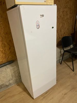 a white refrigerator with a microwave on top of it