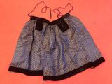 a close up of a skirt with a bow on it on a pink surface