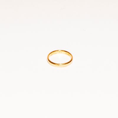 a gold ring on a white surface