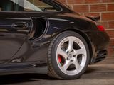 a black car parked in front of a brick wall