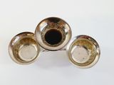 three silver plated cups and saucers sitting on a white surface