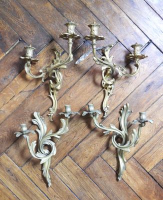 three antique brass wall sconces on a wooden floor
