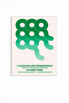 une affiche verte et blanche ornée de cercles, accrochée sur un mur blanc
