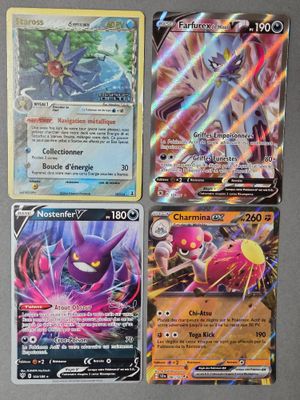 Quatre cartes Pokémon différentes sont posées sur une table.