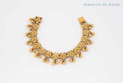 a close up of a gold necklace on a white surface